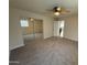 Spacious bedroom featuring neutral carpet, ceiling fan, and a closet with mirrored sliding doors at 1841 N Wilbur Cir, Mesa, AZ 85201