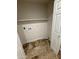 Functional laundry room featuring tile floors, shelving, and hookups for washer and dryer at 1841 N Wilbur Cir, Mesa, AZ 85201