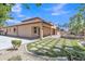 Rear exterior view of the home showcasing the outdoor kitchen and manicured lawn at 2652 N 143Rd Dr, Goodyear, AZ 85395
