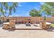 Inviting backyard with custom brick barbecue, firepit, seat, and stone accents at 2652 N 143Rd Dr, Goodyear, AZ 85395