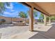 A covered patio with pavers leads to a built in barbeque and artificial turf at 2652 N 143Rd Dr, Goodyear, AZ 85395