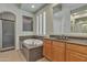 Bright bathroom featuring a soaking tub beneath a window and a separate shower at 2652 N 143Rd Dr, Goodyear, AZ 85395