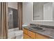 Bathroom featuring a gray countertop, wooden cabinets, tub and patterned shower curtain at 2652 N 143Rd Dr, Goodyear, AZ 85395
