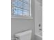 Bathroom featuring white toilet and tub with shower fixture alongside a window with blinds at 2652 N 143Rd Dr, Goodyear, AZ 85395