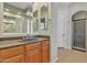 Bathroom featuring double sinks, a separate shower, and a doorway to another room at 2652 N 143Rd Dr, Goodyear, AZ 85395