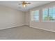 Spacious bedroom featuring neutral carpet, natural light from shuttered windows, and a ceiling fan at 2652 N 143Rd Dr, Goodyear, AZ 85395