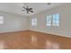 Spacious bedroom featuring wood flooring, natural light from shuttered windows, and a ceiling fan at 2652 N 143Rd Dr, Goodyear, AZ 85395
