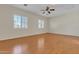 Spacious bedroom featuring wood flooring, natural light from shuttered windows, and a ceiling fan at 2652 N 143Rd Dr, Goodyear, AZ 85395