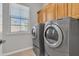 A well-equipped laundry room with washer, dryer and plenty of storage at 2652 N 143Rd Dr, Goodyear, AZ 85395