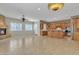 Open-concept living room with fireplace, tile flooring, and seamless access to kitchen at 2652 N 143Rd Dr, Goodyear, AZ 85395