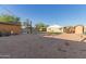 Wide backyard view with sheds, gravel, partial lawn, and privacy fence at 332 S 83Rd Pl, Mesa, AZ 85208