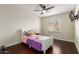 This cozy bedroom has hardwood floors, a ceiling fan, and a bright window at 332 S 83Rd Pl, Mesa, AZ 85208