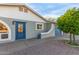 Charming home with blue door and mature landscaping, set against a clear blue sky at 332 S 83Rd Pl, Mesa, AZ 85208