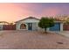 Charming single-story home with blue accents and a unique arched window, set against a desert landscape at 332 S 83Rd Pl, Mesa, AZ 85208