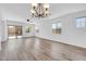 Bright living room showcasing light wood floors, ample windows, and a decorative chandelier at 3898 E Palmer St, Gilbert, AZ 85298