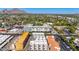 An aerial view capturing the modern apartment complex and surrounding neighborhood with green trees, under a clear blue sky at 4220 N 32Nd St # 14, Phoenix, AZ 85018