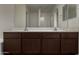 Bright bathroom featuring a double sink vanity with dark cabinets and a large mirror at 4745 W Fremont Rd, Laveen, AZ 85339