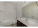 Bright bathroom featuring a shower-tub combo, vanity with sink, and a large mirror at 4745 W Fremont Rd, Laveen, AZ 85339