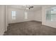 This bedroom features three large windows, a ceiling fan, and neutral carpet at 4745 W Fremont Rd, Laveen, AZ 85339
