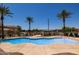 Community pool with inviting blue water, palm trees, and a shaded gazebo area at 4745 W Fremont Rd, Laveen, AZ 85339