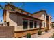 Side of a tan stucco house with a tiled roof, paver walkway, desert landscaping, and green shrubs at 4745 W Fremont Rd, Laveen, AZ 85339