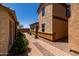 Side view of a stucco house with a tiled roof, well-kept landscaping, and a brick paver driveway at 4745 W Fremont Rd, Laveen, AZ 85339