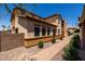Side of a tan stucco house with a tiled roof, paver walkway, desert landscaping, and green shrubs at 4745 W Fremont Rd, Laveen, AZ 85339
