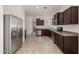 Bright kitchen featuring stainless steel appliances, dark wood cabinets, and durable tile flooring at 4745 W Fremont Rd, Laveen, AZ 85339
