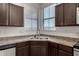 Kitchen features a stainless steel sink, dark cabinetry, and a window for natural light at 4745 W Fremont Rd, Laveen, AZ 85339
