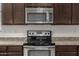 The kitchen features stainless steel appliances, granite countertops, and dark wood cabinets at 4745 W Fremont Rd, Laveen, AZ 85339