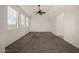 Bright and airy living room featuring neutral walls, carpet, tile flooring, three windows and a ceiling fan at 4745 W Fremont Rd, Laveen, AZ 85339