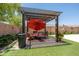 Relaxing backyard pergola area with an outdoor seating set and artificial turf at 5737 W Hidalgo Ave, Laveen, AZ 85339