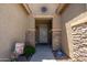Inviting front entry with stone accents, decorative sunburst, and colorful landscaping at 5737 W Hidalgo Ave, Laveen, AZ 85339