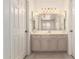 Bathroom vanity features tiled floors, bright lights, a large decorative mirror and closet doors at 64 N 63Rd St # 25, Mesa, AZ 85205