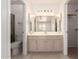A bathroom vanity featuring tiled floors, bright lights and a large decorative mirror at 64 N 63Rd St # 25, Mesa, AZ 85205