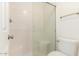 Bright bathroom featuring a tiled shower with glass door and an elongated toilet at 64 N 63Rd St # 25, Mesa, AZ 85205