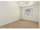 Bedroom with neutral walls and carpet flooring, features a window view and bright lights at 64 N 63Rd St # 25, Mesa, AZ 85205