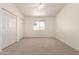 Bright bedroom featuring neutral carpet, ceiling fan, window view and closet doors at 64 N 63Rd St # 25, Mesa, AZ 85205