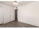 A standard bedroom with closet, wood-look floors, and a ceiling fan at 6606 N 46Th Ave, Glendale, AZ 85301