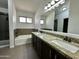 This bathroom features double sink with granite counters, bathtub and glass shower at 740 W Dublin St, Gilbert, AZ 85233