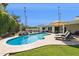Backyard pool with rock waterfall feature, lounge chairs and green lawn at 8045 E Del Caverna Dr, Scottsdale, AZ 85258