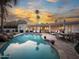 A backyard pool area with desert landscaping, lounge chairs and sunset sky at 8045 E Del Caverna Dr, Scottsdale, AZ 85258