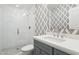 Stylish bathroom showcasing marble countertops, gray cabinets, and a glass shower with white tile at 8045 E Del Caverna Dr, Scottsdale, AZ 85258
