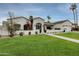 Beautiful single-Gathering home featuring a well-manicured lawn, mature trees, and a charming facade at 8045 E Del Caverna Dr, Scottsdale, AZ 85258