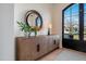 Elegant foyer with modern accents including wooden cabinet, round mirror and decor at 8045 E Del Caverna Dr, Scottsdale, AZ 85258