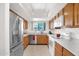 Efficient kitchen features stainless steel refrigerator and appliances with bright overhead lighting at 8651 E Royal Palm Rd # 121, Scottsdale, AZ 85258