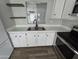 Close-up of the updated kitchen sink with floating shelves, new faucet and appliances at 918 S Evangeline Ave, Mesa, AZ 85208