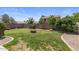 Generous backyard space with a circular fire pit, rock landscaping, and lush green lawn at 9329 E Olla Ave, Mesa, AZ 85212