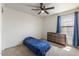 Bright bedroom with neutral carpet, ceiling fan, and large window that allows in natural light at 9329 E Olla Ave, Mesa, AZ 85212