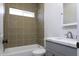 Bathroom features tile surround, tub, window, and vanity with modern sink at 10772 N Biznaga St, Florence, AZ 85132